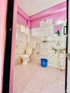 une salle de bains rose avec toilettes et lavabo. dans l'établissement Hotel Santana, à Pokhara