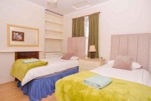 a bedroom with two beds with yellow blankets on them at pedro host family in London