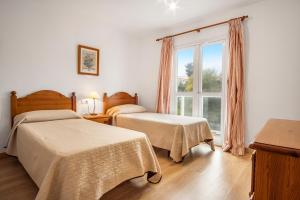 a bedroom with two beds and a window at Duquesa Harbour Club Aparthotel in Manilva