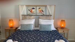 ein Schlafzimmer mit einem Bett mit zwei Lampen auf zwei Tischen in der Unterkunft Casa do Açor - Villaverde Azores in Feteiras + 49 Fotos