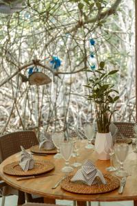 a wooden table with plates and wine glasses on it at Fragata Island House in Cartagena de Indias