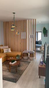 ein Wohnzimmer mit Sofa und Tisch in der Unterkunft Casa do Açor - Villaverde Azores in Feteiras