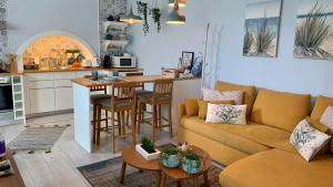 a living room with a couch and a kitchen at Casa do Açor - Villaverde Azores in Feteiras