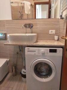 łazienka z umywalką i pralką w obiekcie La Nena Appartamenti w mieście La Spezia