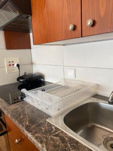 a kitchen counter with a sink and a dish rack at Alex Beach Apartment 33 in Larnaka +59 photos