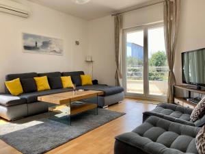 a living room with a couch and a tv at Sunny apartment by the beach in Kastel Stafilic