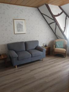 a living room with a blue couch in a attic at Mosea in Zeltingen-Rachtig