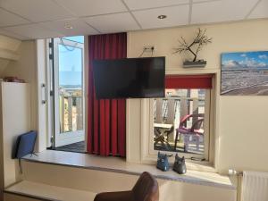 una camera con TV a schermo piatto su una finestra di pension canberra a Bergen aan Zee