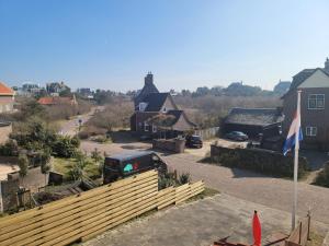 a view of a house with a fence and a flag at pension canberra in Bergen aan Zee