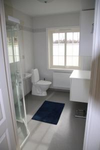 un bagno bianco con un water e un lavandino di Värmvik Gårdskontor a Västervik