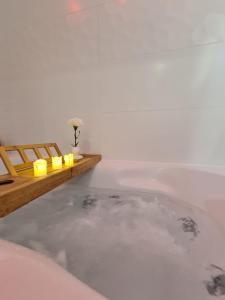 a bath tub with candles in a white room at Le raffiné-parking privé-proche frontière Bâle in Saint-Louis