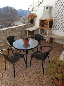 um pátio com uma mesa, cadeiras e um fogão em La casa de Tento em Tózar