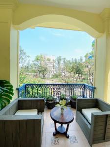 einen Balkon mit einem Tisch und einem großen Fenster in der Unterkunft Thi Boutique Villa in Đà Nẵng