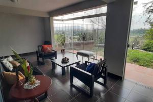 sala de estar con muebles y ventana grande en Residencia en Tomatitas en Tarija