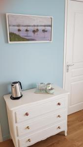 a white dresser in a room with a painting on the wall at Couette et café Saumur in Saumur