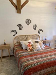 een slaapkamer met een bed met kussens en klokken aan de muur bij Morvan Séjours in Antully