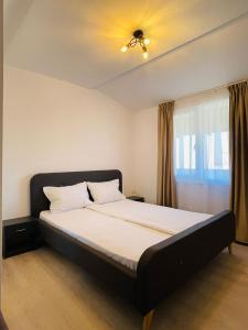 a large bed in a room with a window at Paradox H in Eforie Sud