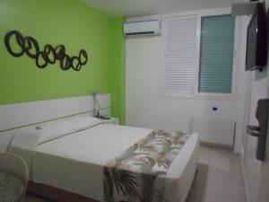 a bedroom with a bed and a green wall at Coqueiros Express Hotel in Maceió +30 photos