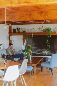 a man sitting on a couch with a laptop in a living room at Selva India Suites in San Carlos de Bariloche