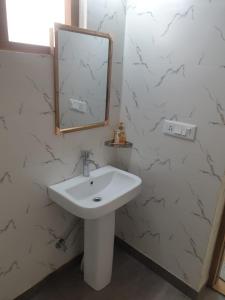 a bathroom with a sink and a mirror on the wall at The Kumaon Retreat in Nainital