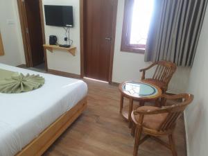 a bedroom with a bed and a chair and a table at The Kumaon Retreat in Nainital +20 photos