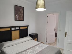 a bedroom with a bed and a pendant light at Casa Selene in El Puerto de Santa María +15 photos