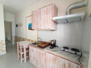a kitchen with wooden cabinets and a sink and a stove at Peaceful Bay in Megas Gialos - Nites