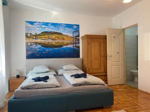 sypialnia z łóżkiem i obrazem na ścianie w obiekcie Balaton7 Apartmanház - Badacsonytomaj Centrum w mieście Badacsonytomaj