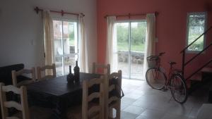 ein Esszimmer mit einem Tisch und einem Fahrrad in der Unterkunft Cabañas Cafayate I in Cafayate