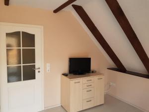 a room with a tv on a dresser with a door at Seeblick in Möllen
