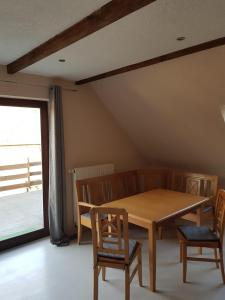 a dining room with a wooden table and two chairs at Seeblick in Möllen