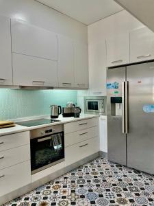 a kitchen with a refrigerator, stove, microwave and dishwasher at Santa Catarina Guest House (Porto city center) in Porto
