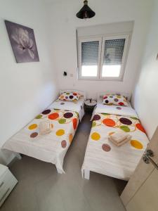 2 Einzelbetten in einem Zimmer mit 2 Fenstern in der Unterkunft Seagull Apartments in Kotor
