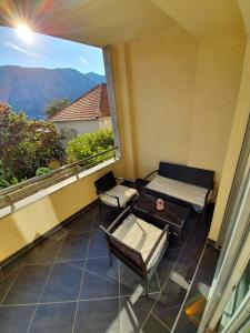 einen Balkon mit einem Bett, einem Sofa und einem Fenster in der Unterkunft Seagull Apartments in Kotor