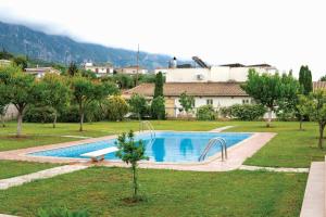 Laki Villa with pool and jacuzzi في Ágios Geórgios: مسبح في حديقة فيها اشجار ومبنى