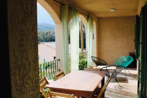 a room with a table and chairs on a balcony at Villa I Bugni in Sisco
