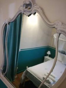 a bed in a room with a mirror at sacrobosco apartment Quercia in Bomarzo