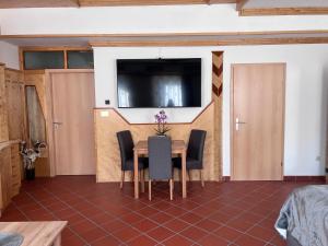 uma sala de jantar com mesa e cadeiras e uma televisão em Fleischerei&Jausenstation Palucaj em Krieglach