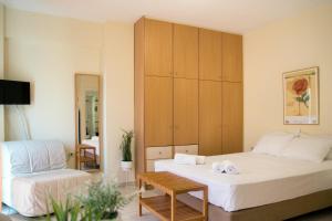 ein Hotelzimmer mit einem Bett und einem Stuhl in der Unterkunft Sunny City Studio in Kalamata