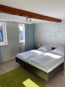 a bedroom with a large bed and a green rug at Urlaub in Kühlungsborn in Fulgen