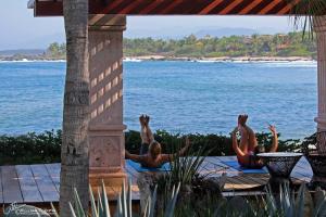 a group of people doing yoga by the water at The Inn Manzanillo Bay in Troncones