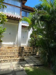 a house with a white door and a palm tree at Departamento Dos reis in Búzios