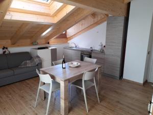 cocina y comedor con mesa de madera y sillas en Pelmo Mountain Lodge, en Selva di Cadore