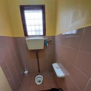 a bathroom with a toilet and a window at HAIDA'S HOMESTAY Seri Iskandar, Perak in Seri Iskandar +5 photos