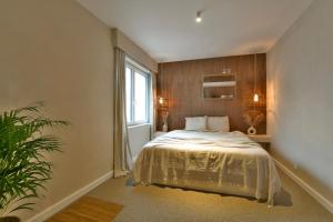 Un dormitorio con una cama grande y una ventana. en Oostending, en Ostende