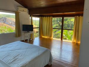 a bedroom with a bed and a large window at Departamento Dos reis in Búzios