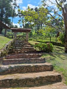 a set of stone stairs in a park with a gate at Chalé na Serra da Mantiqueira in Campos do Jordão