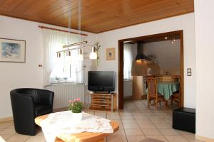 ein Wohnzimmer mit einem Tisch und einem TV in der Unterkunft Ferienwohnung Niemeier in Hoppecke