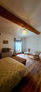 1 dormitorio con cama, mesa y ventana en Villa Misanid écrin de verdure à 15mm de la cité de Carcassonne, en Mas-des-Cours