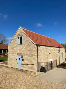 un petit bâtiment en briques avec un toit rouge dans l'établissement Farriers Cottage, à Grantham